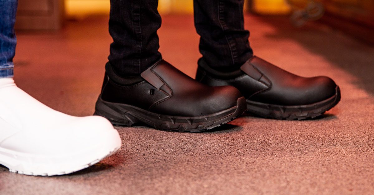 A female butcher working on her feet while wearing Shoes For Crews footwear with safety measures to prevent work-related injuries