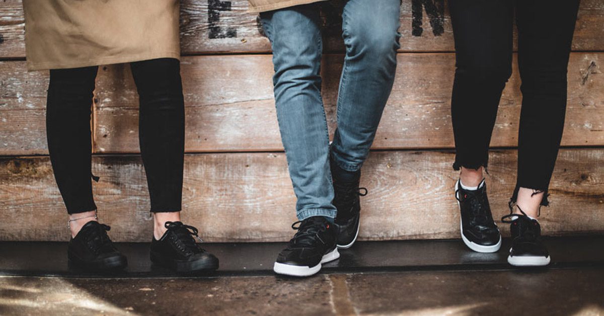 Three servers standing at bar wearing supportive, slip-resistant footwear