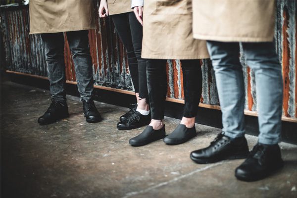 Four restaurant servers standing on the main floor wearing supportive slip-resistant footwear