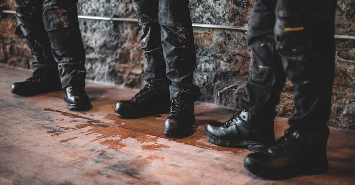 Three construction workers wearing black, slip-resistant work boots