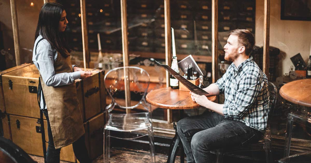 Waitress talking to customer and taking order while wearing high-quality, smart, black work shoes