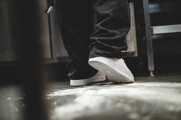 Kitchen worker stepping in flour wearing white slip-resistant shoes
