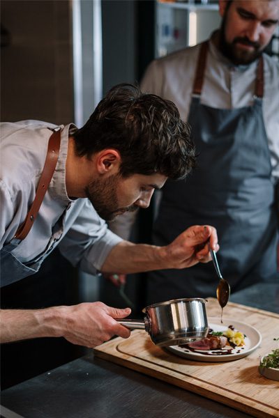 Cuisinier dressant une assiette de boeuf