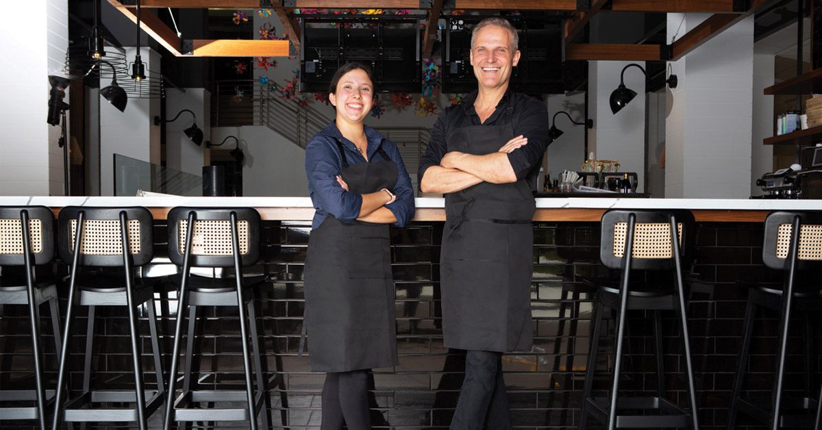 Deux serveurs équipés de chaussures de travail devant le comptoir d'un restaurant