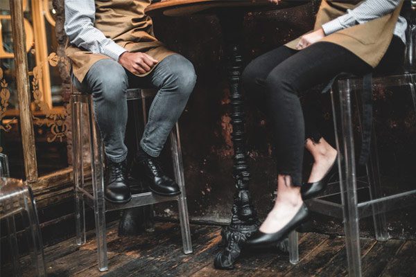 Pies de dos camareros con calzado laboral 