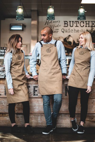 Servers leaning on butcher’s counter wearing lightweight black Delray, Freestyle and Liberty shoe styles