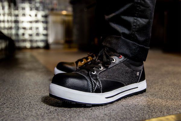 Kitchen staff worker wearing black supportive, lightweight work shoes with white outsoles