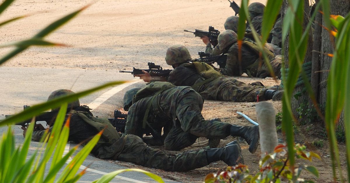 Army personnel running simulation drills on the beach