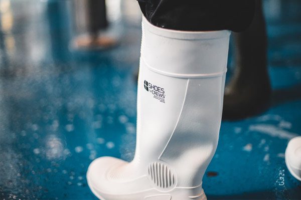 Manufacturing worker wearing white slip-resistant Wellingtons on smooth surface