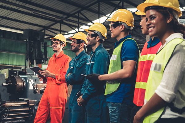 Travailleurs dans une usine recevant une formation sur les risques du travail à la chaîne