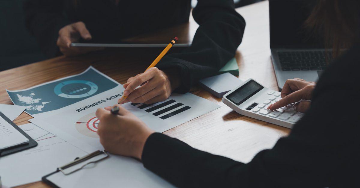 Employees analysing business goals and budgets at a long table