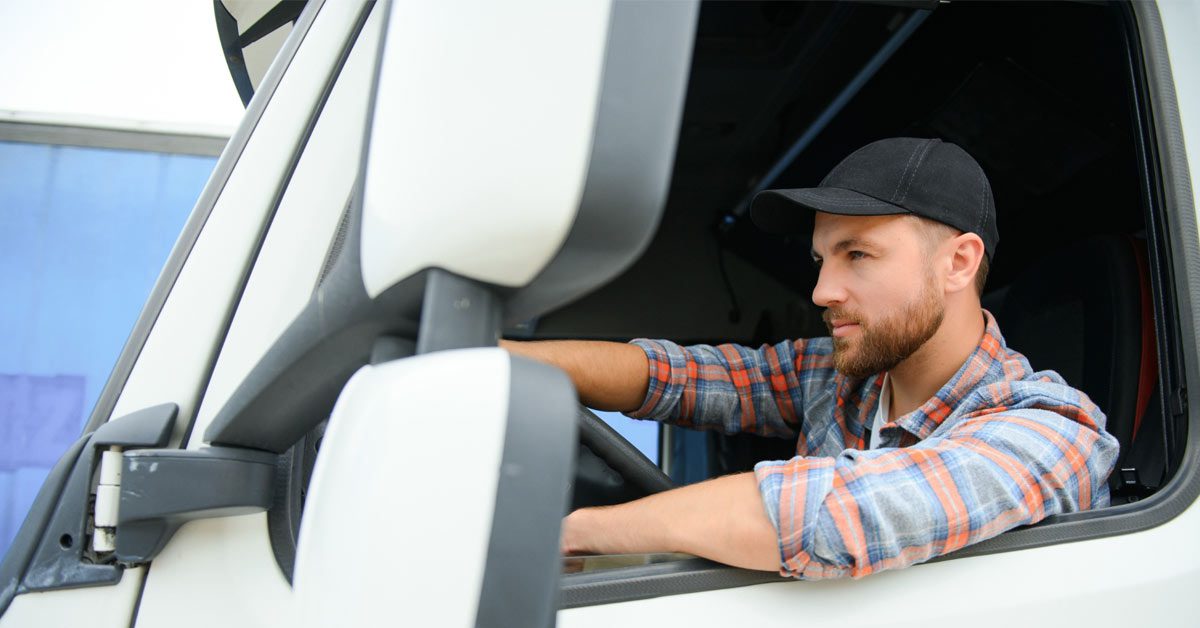 Conductor al volante en la cabina de su vehículo