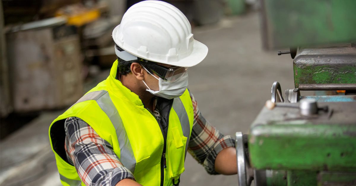 Travailleur de l’industrie manufacturière actionnant les machines au premier plan