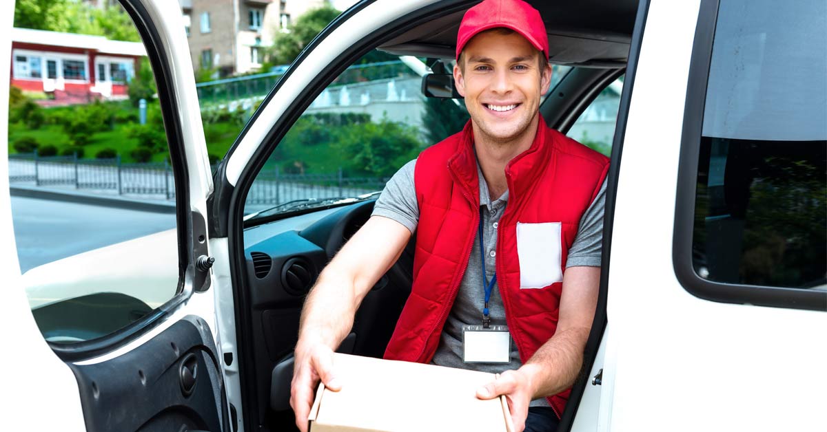 Logistics worker holding a parcel and sitting in a van with door open