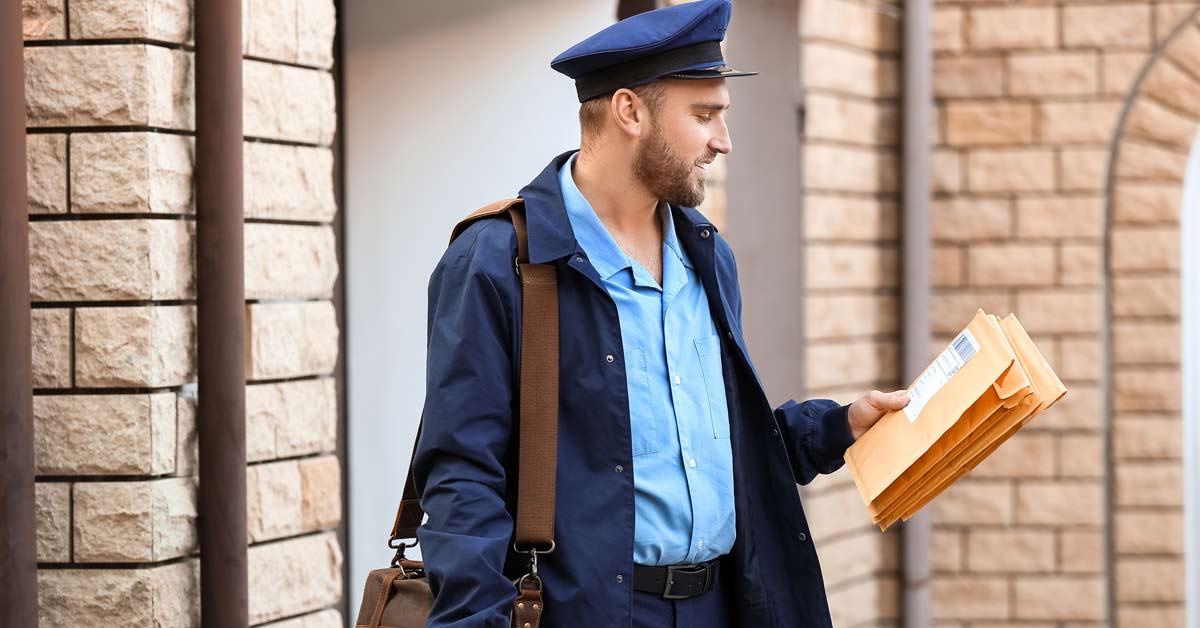 Facteur en tenue livrant le courrier