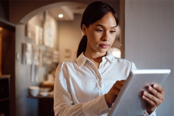 Hospitality worker working on a tablet in a café setting