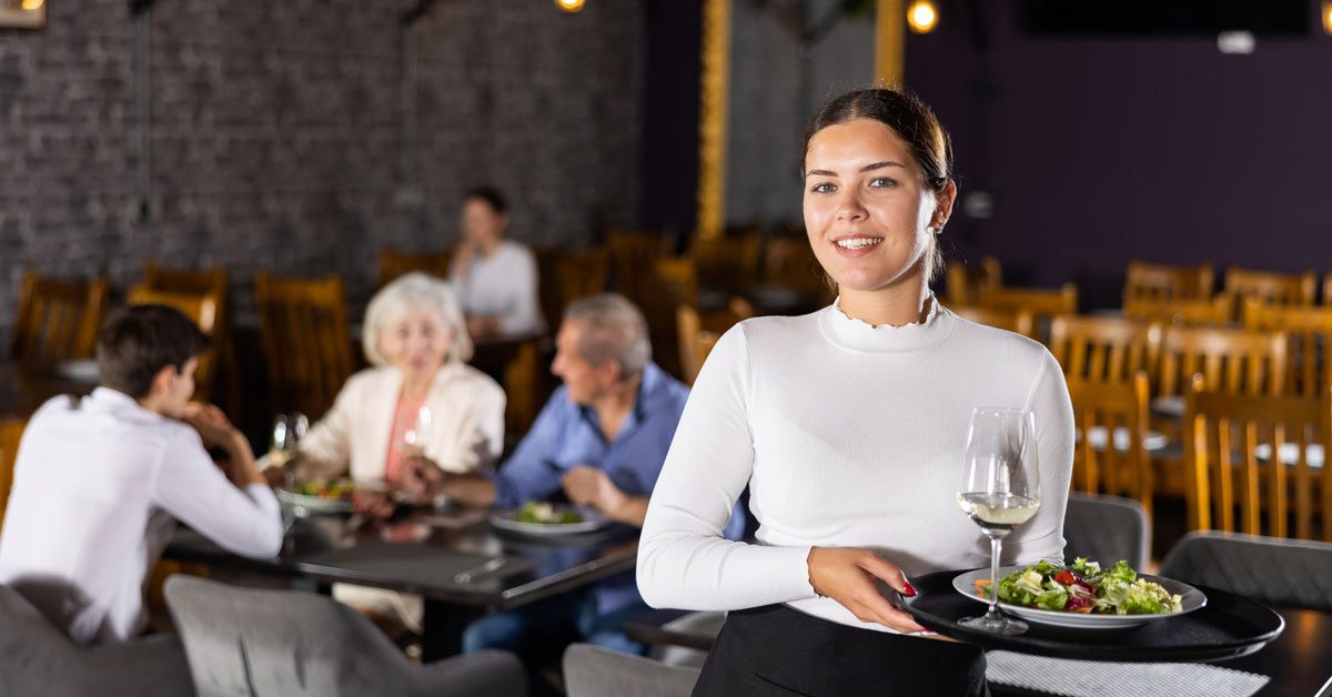 Eine stilvoll gekleidete Kellnerin bedient in einem Restaurant