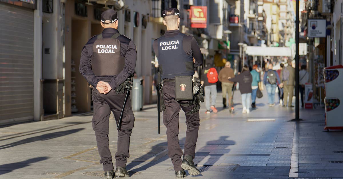 Dos policías locales patrullan por la calle de una ciudad