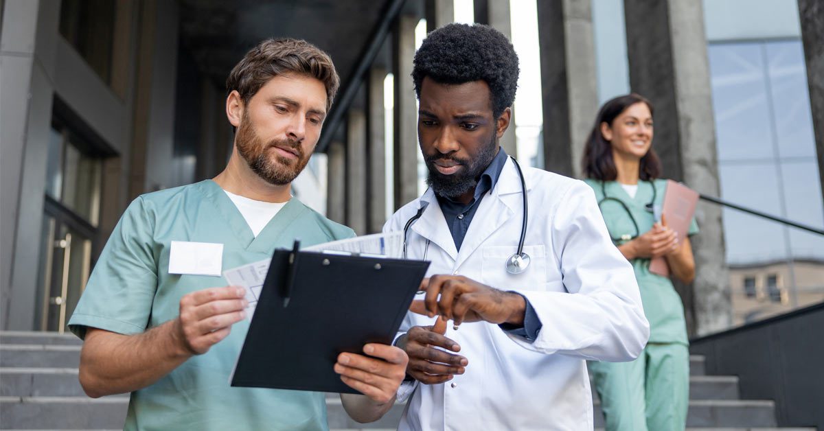 Two doctors going over a report on clipboard at hospital