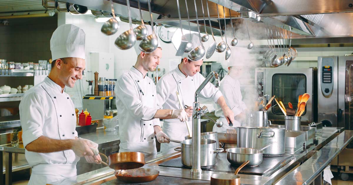Un equipo de cocineros prepara la comida en la cocina de un restaurante