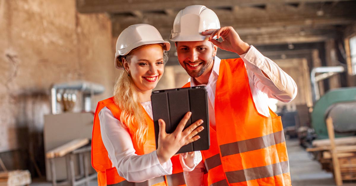 Two quality control workers in warehouse reviewing safety and health checklist