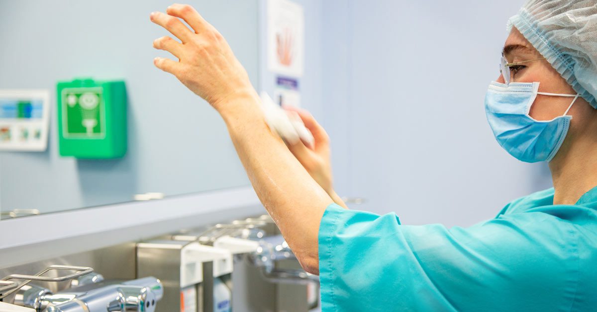 Eine Pflegekraft, die ihre Hände desinfiziert.